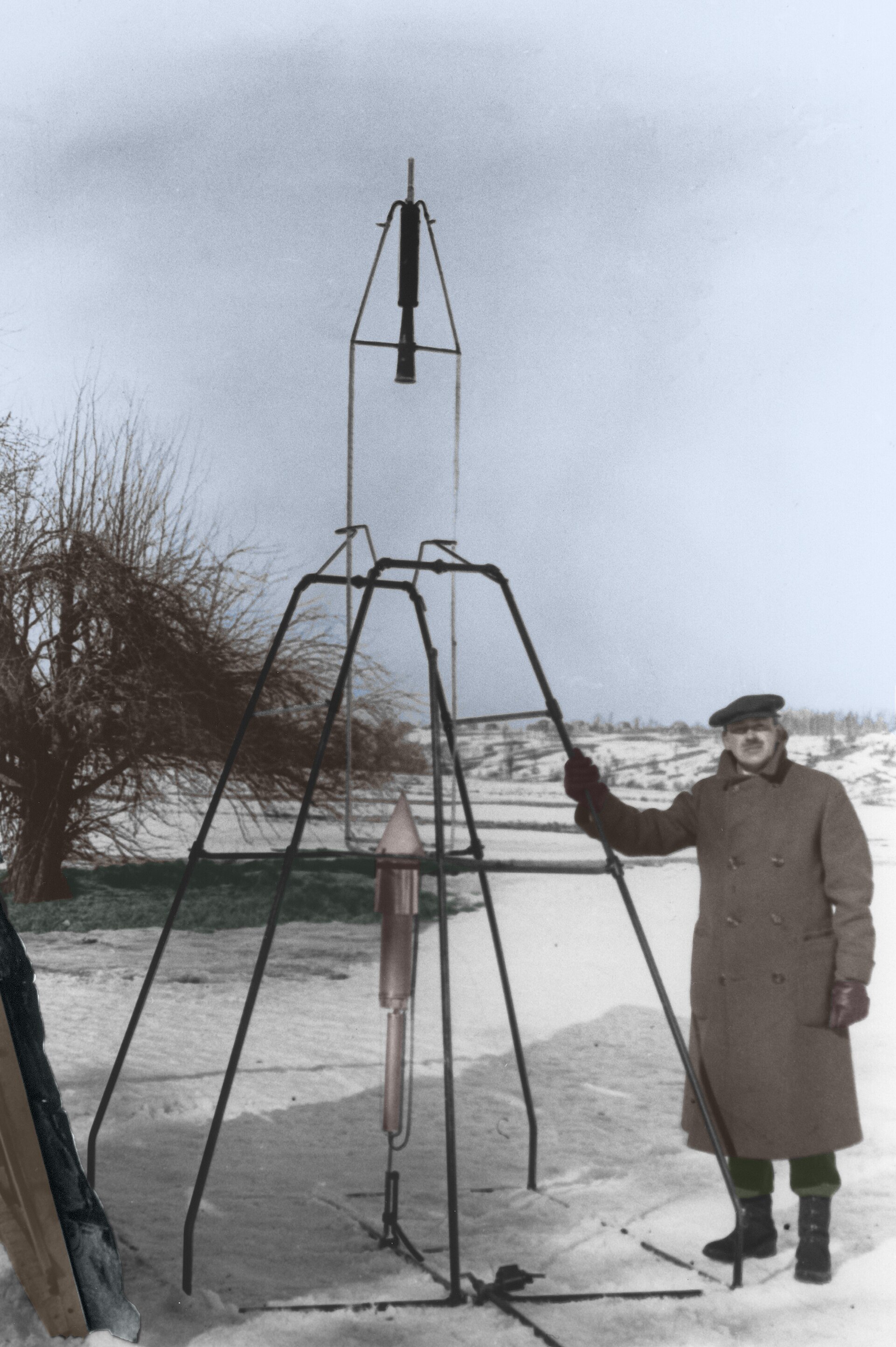 Robert Goddard standing next to his liquid-fueled rocket